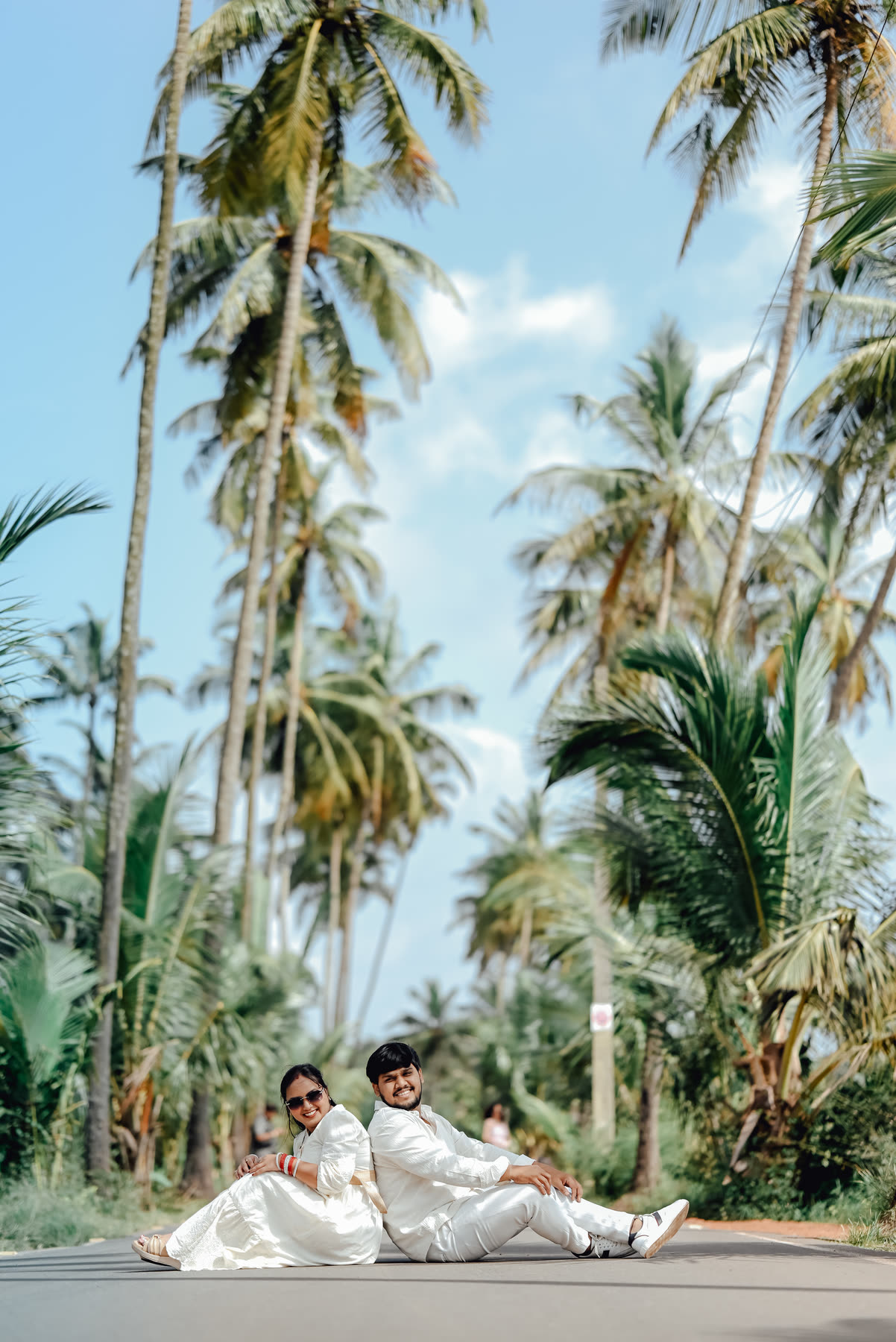 Seated together on an empty coconut-palm road