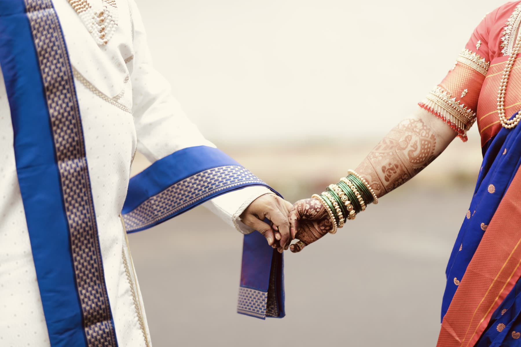 Green chuda and mehendi, hands clasped between functions