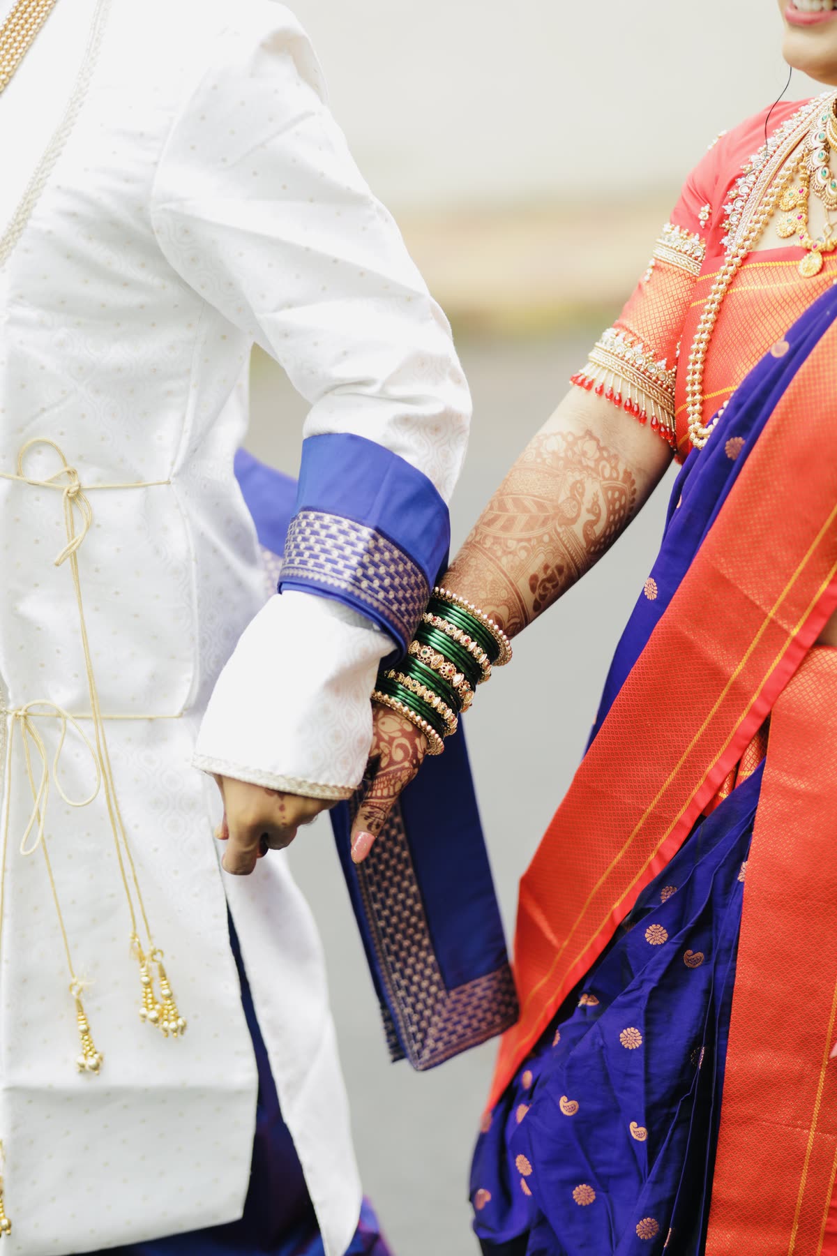 Bangles, mehendi and held hands in close detail