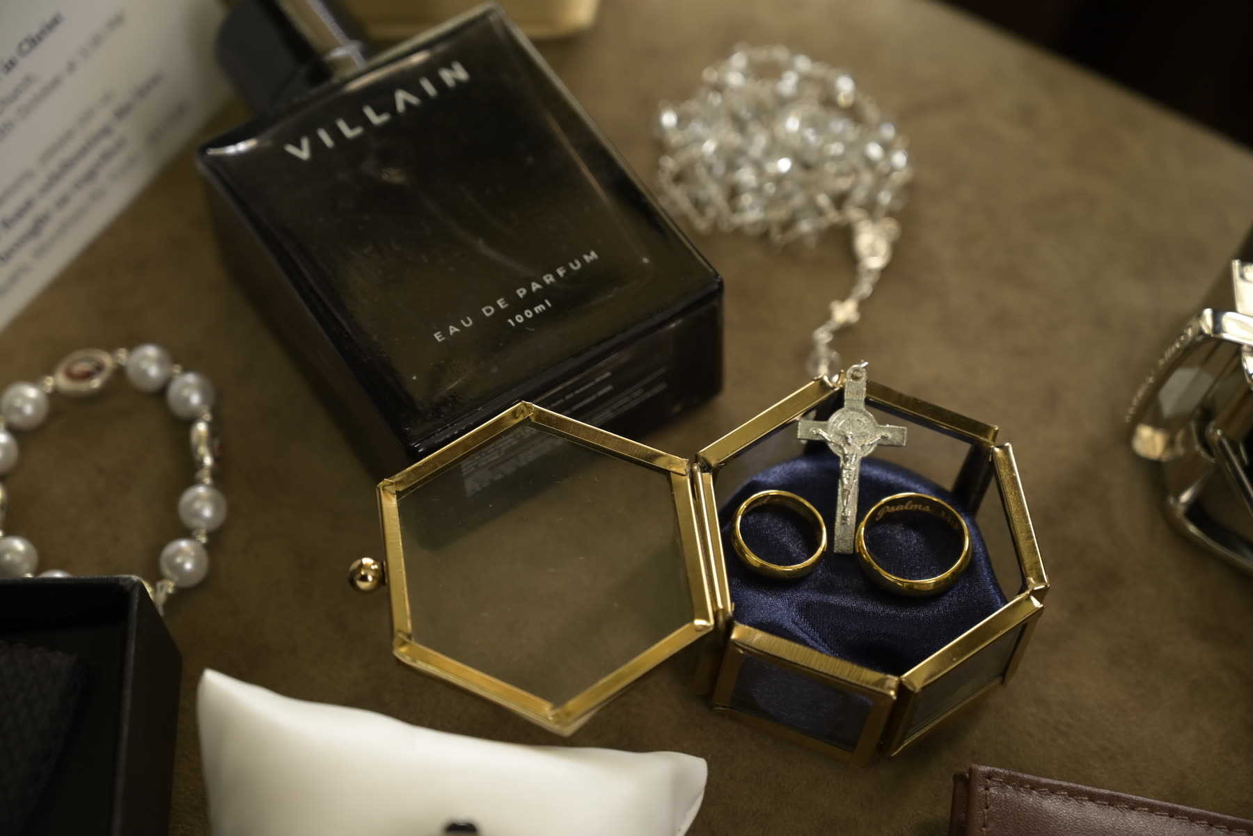 Rings in a glass case beside a rosary