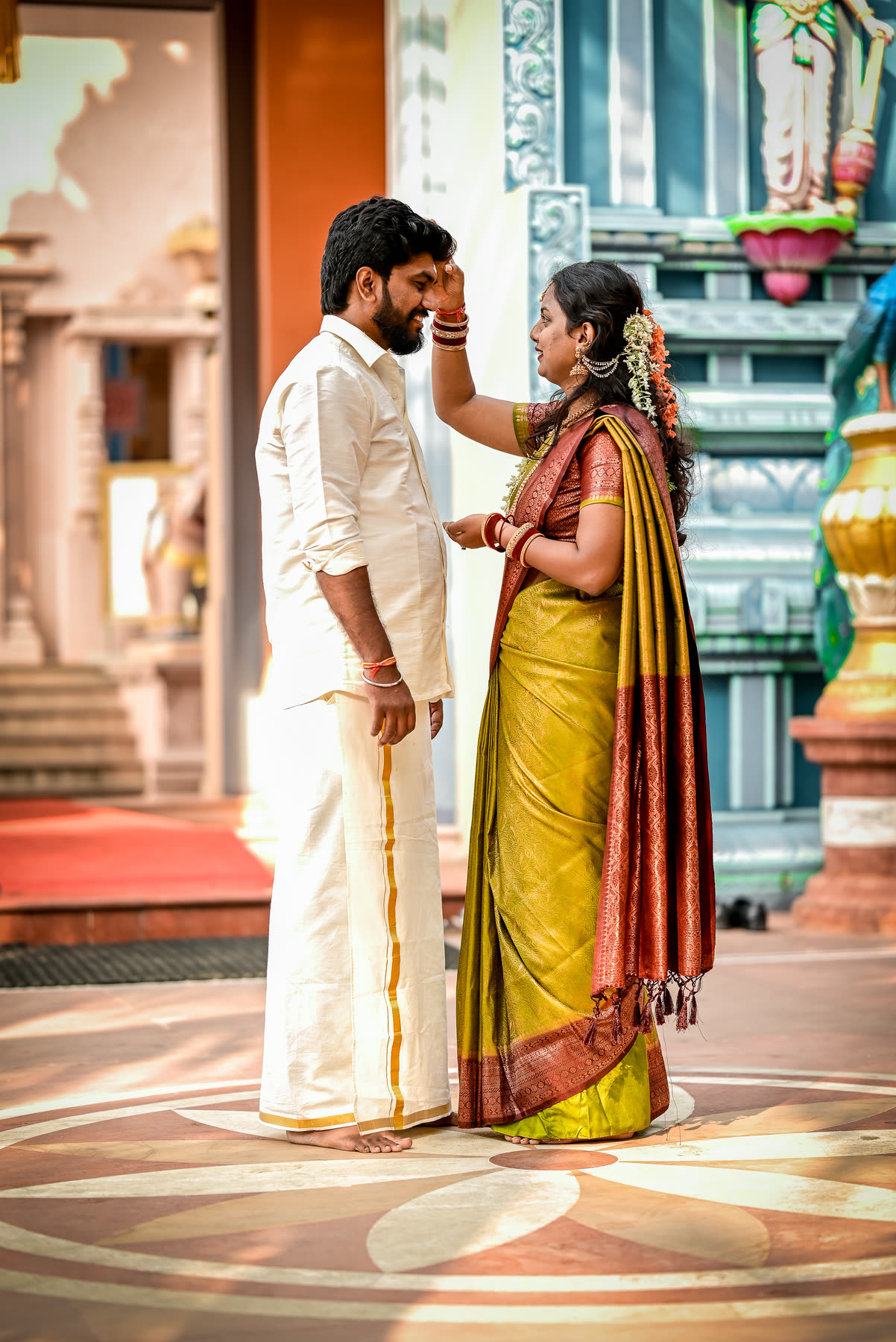 Marking his forehead with tilak at the temple